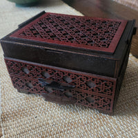 Decorative wooden box with intricate carvings on a textured surface