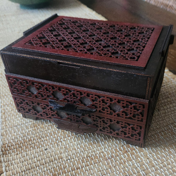 Decorative wooden box with intricate carvings on a textured surface