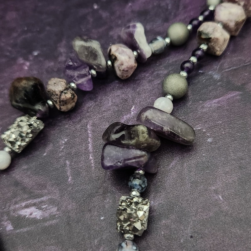 Wear the Velavee Angel Necklace and radiate your inner goddess! Crafted from sterling silver and the rare gemstone Charoite, this one-of-a-kind necklace is adorned with angel wing and a inverted fan shaped medallion, creating a beautiful and unique statement. 