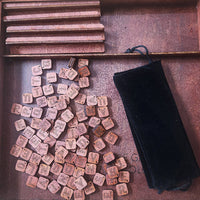 Wooden letter tiles and a velvet pouch on a wooden tray