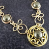 The Celtic Priestess Triquetra Medallion Collar features chain links inspired by Celtic knots, all created entirely by hand using only a few hand tools. The links are then tumbled with steel shot, creating strength and durability, as well as a silky smoothness.   The center medallion is a gold plated Celtic Triquetra Knot set with natural Pyrite. My Secret Heart Studios