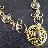 The Celtic Priestess Triquetra Medallion Collar features chain links inspired by Celtic knots, all created entirely by hand using only a few hand tools. The links are then tumbled with steel shot, creating strength and durability, as well as a silky smoothness.   The center medallion is a gold plated Celtic Triquetra Knot set with natural Pyrite. My Secret Heart Studios