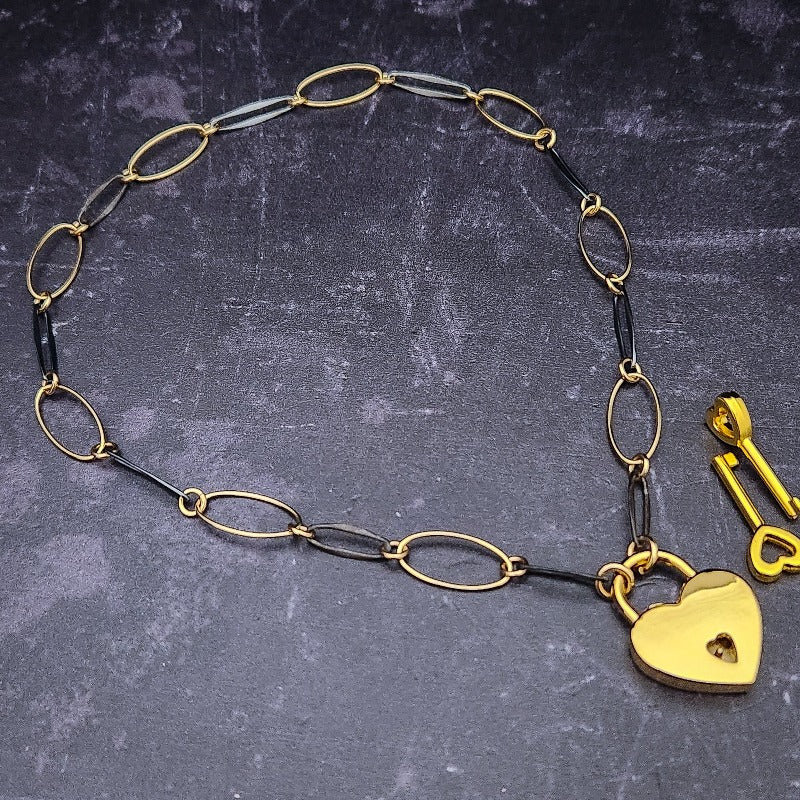  Opulent is sure to make a striking statement day or night. The chain is easily transformed into stylish handcuff or ankle restraint, a chic locking collar, or a decorative necklace for Dominants. Connect it to the back of a collar for a sexy look, and give a tug on the chain for an extra choking sensation. Handcrafted in blackened sterling and gold links, Opulent is beautifully dramatic and luxurious, 