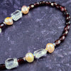 This ONE OF A KIND locking submissive ANGEL WING GEMSTON E COLLAR pays homage to your BDSM D/s lifestyle with beauty and grace. Locks in front. GEMSTONES: Faceted Amethyst Nuggets, Cushion Cut Labradorite , Faceted Tanzanite Rondels & Faceted Grey Moonstone