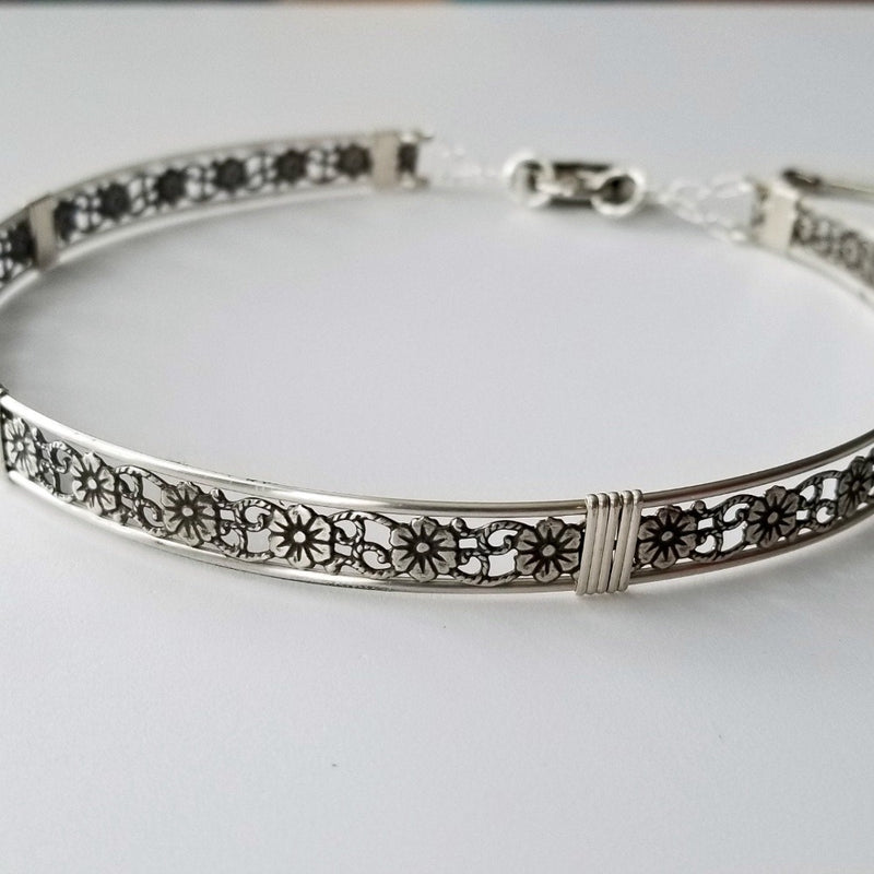 Our most delicate and feminine submissive locking collar. A simply sweet floral and vine pattern of sterling silver and wire wrapped with precious metal accents. BDSM? No one will know. Totally discreet.