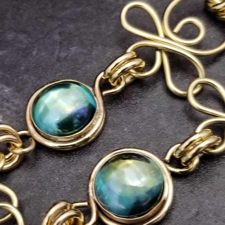 Made a bold statement of your Dominant / submissive lifestyle. The CELTIC PRIESTESS locking submissive collar features chain links inspired by Celtic knots, all created entirely by hand. Embellished with 2 natural gemstone cabochons of your choice.