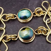 Features chain links inspired by Celtic knots, all created entirely by hand using only a few hand tools. The links are then tumbled with steel shot, creating strength and durability, as well as a silky smoothness.   The center medallion is a gold plated Celtic Triquetra Knot set with natural Rainbow Topaz. By My Secret Heart Studios.