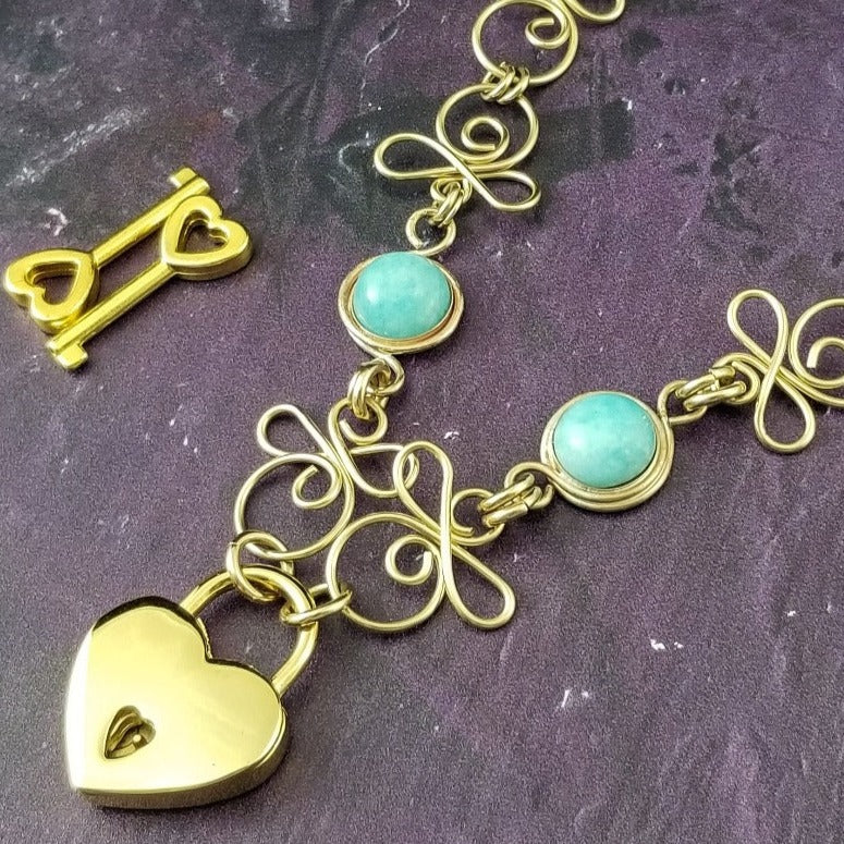 Made a bold statement of your Dominant / submissive lifestyle. The CELTIC PRIESTESS locking submissive collar features chain links inspired by Celtic knots, all created entirely by hand. Embellished with 2 natural amazonite cabochons of your choice. My Secret Heart Studios 001