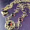 THE CELTIC PRIESTESS LOCKING BELT features chain links inspired by Celtic knots, all created entirely by hand using only a few hand tools. The links are then tumbled with steel shot, creating strength and durability, as well as a silky smoothness. Garnet and Gold Filled. By My Secret Heart Studios