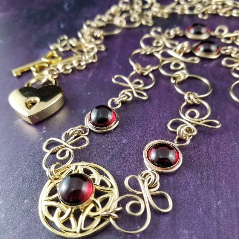 THE CELTIC PRIESTESS LOCKING BELT features chain links inspired by Celtic knots, all created entirely by hand using only a few hand tools. The links are then tumbled with steel shot, creating strength and durability, as well as a silky smoothness. Garnet and Gold Filled. By My Secret Heart Studios