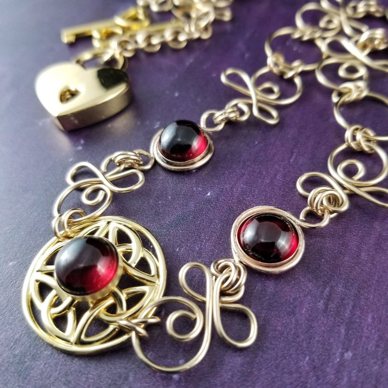 THE CELTIC PRIESTESS LOCKING BELT features chain links inspired by Celtic knots, all created entirely by hand using only a few hand tools. The links are then tumbled with steel shot, creating strength and durability, as well as a silky smoothness. Garnet and Gold Filled. By My Secret Heart Studios