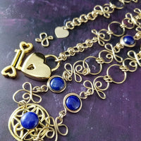 THE CELTIC PRIESTESS LOCKING BELT features chain links inspired by Celtic knots, all created entirely by hand using only a few hand tools. The links are then tumbled with steel shot, creating strength and durability, as well as a silky smoothness. Lapis Lazuli and Gold Filled. By My Secret Heart Studios
