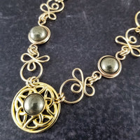 The Celtic Priestess Triquetra Medallion Collar features chain links inspired by Celtic knots, all created entirely by hand using only a few hand tools. The links are then tumbled with steel shot, creating strength and durability, as well as a silky smoothness.   The center medallion is a gold plated Celtic Triquetra Knot set with natural Pyrite. My Secret Heart Studios