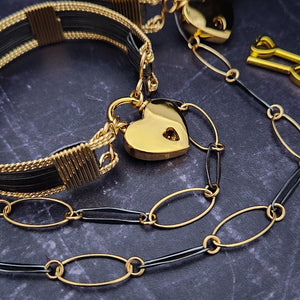  Opulent is sure to make a striking statement day or night. The chain is easily transformed into stylish handcuff or ankle restraint, a chic locking collar, or a decorative necklace for Dominants. Connect it to the back of a collar for a sexy look, and give a tug on the chain for an extra choking sensation. Handcrafted in blackened sterling and gold links, Opulent is beautifully dramatic and luxurious.