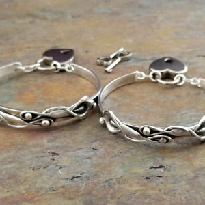 The Calla Lily Handcuff bracelets are a graceful addition to our artisan BDSM jewelry collection. Your submissive is sure to love this feminine and elegant locking cuff. Made in solid sterling silver, with a few links of chain to create a comfortable, 'movable' fit, even when locked. Total discretion!