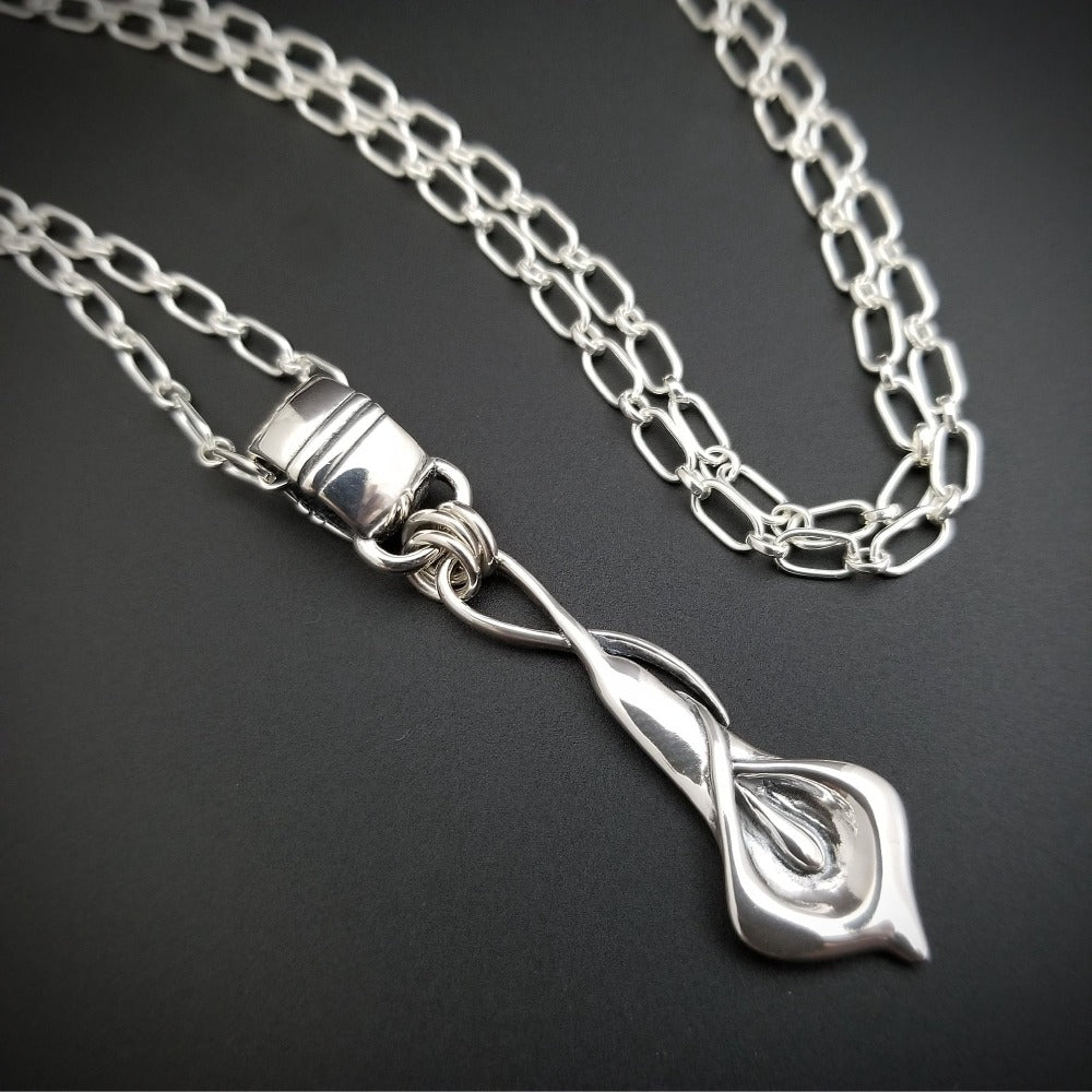 Nature Inspired. Graceful and timeless. This locking submissive BDSM soft collar is the epitome of discretion. The Calla Lily hangs from a sterling chain, but can be removed and slipped onto several of our MSHS submissive collars. Or the 'slide' can also be worn on chains, leather, ribbon, etc. Three versions available: Traditional, Permanently Locking or Lock and Key.