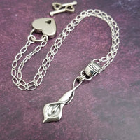 Nature Inspired. Graceful and timeless. This locking submissive BDSM soft collar is the epitome of discretion. The Calla Lily hangs from a sterling chain, but can be removed and slipped onto several of our MSHS submissive collars. Or the 'slide' can also be worn on chains, leather, ribbon, etc. Three versions available: Traditional, Permanently Locking or Lock and Key.