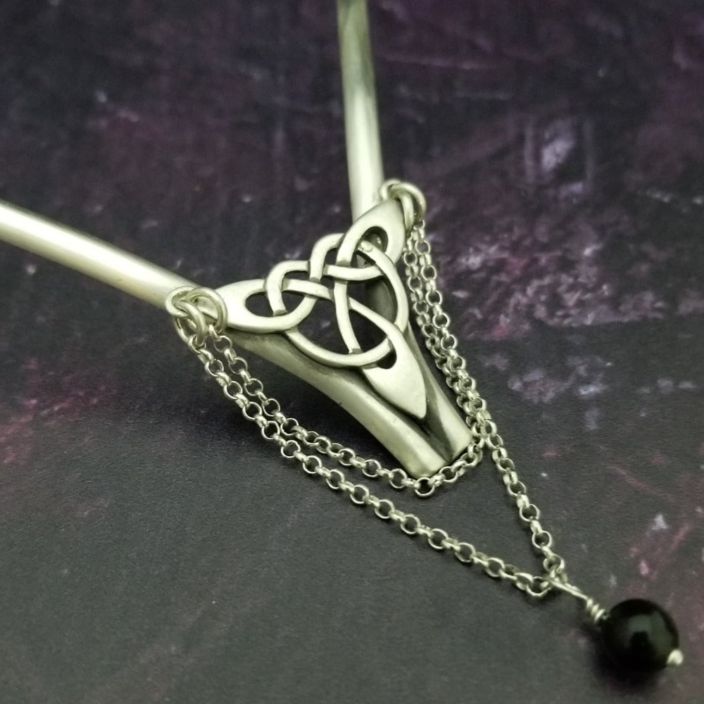 Inspired by campfires, music and moonlight dancing. Ancient past, present and future. Substantial open back style collar has a nice fluid curve that hugs the neck. Celtic knot with swag chain and black onyx bead. Created in all luxurious sterling silver, its solid, weighty construction makes it a timeless piece that you'll be able to enjoy for years to come. My Secret Heart Studios