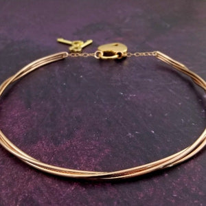 Precious metals are gently woven together into a locking submissive collar that is pure luxury. Beautifully discreet for day wear, it certainly looks like a traditional collar, but ... a lock in the back reminds the submissive of their trust and devotion to their Dominant.  Can be worn locked or with a traditional clasp for total discretion.
