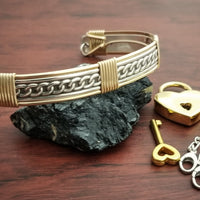 This sterling silver Key Cuff is created with a detachable chain that holds the key to Your slave or sub's locked collars or cuffs. Jewelry clasps clip into rings that attach to the cuff, which makes removing the chain simple. 
