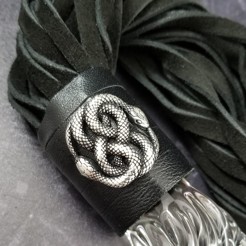 Oh, such a sexy beast! The EDEN BDSM flogger features a sterling silver medallion of two entwined snakes. The weighty solid glass handle gives you the feeling of power, and doubles as a glass dildo for vaginal or anal play.