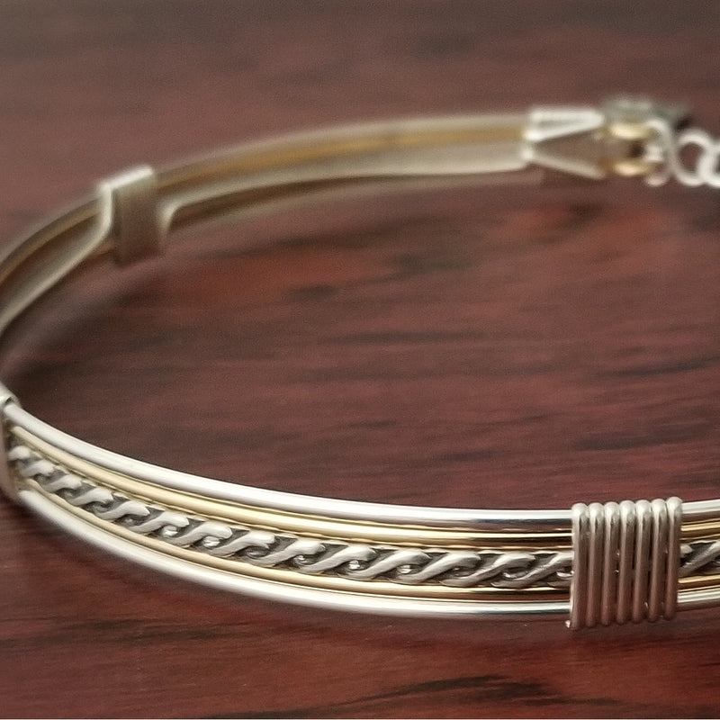 Sterling submissive collar that is discreet for daytime, yet kinky for playtime. The Celtic inspired design features a rope pattern, with accent lines of sterling and 14k gold filled, all wrapped together with sterling wraps. 