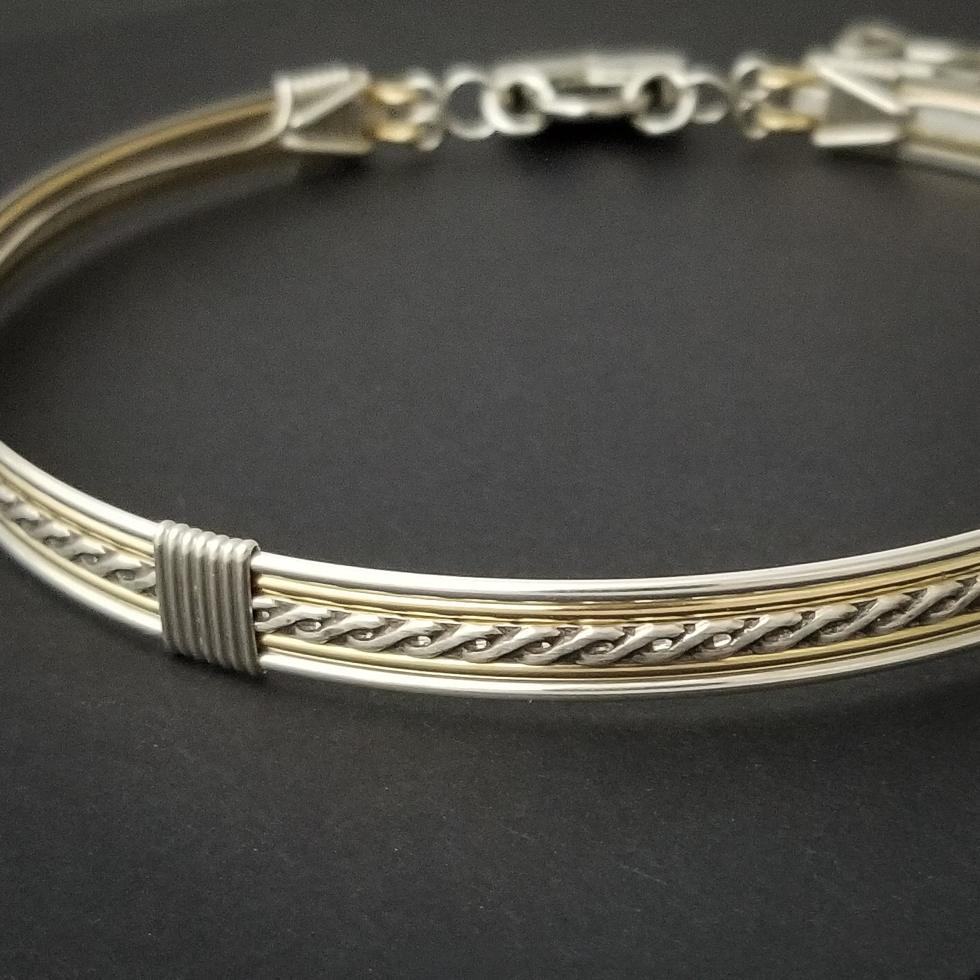Sterling submissive collar that is discreet for daytime, yet kinky for playtime. The Celtic inspired design features a rope pattern, with accent lines of sterling and 14k gold filled, all wrapped together with sterling wraps. 