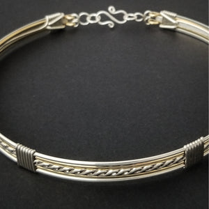 Sterling submissive collar that is discreet for daytime, yet kinky for playtime. The Celtic inspired design features a rope pattern, with accent lines of sterling and 14k gold filled, all wrapped together with sterling wraps. 
