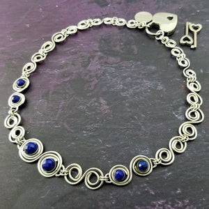 Featuring handcrafted Infinity links made of precious metals and embellished with gemstones. This submissive collar can be worn locked, or with a traditional clasp for total discretion. {All included}. 