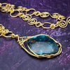  The focal pendant is a large oval cabochon set in a handcrafted wire wrapped gold frame