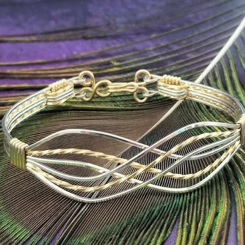 Symbolizes enduring love and commitment. Handcrafted in strands of both smooth and hand twisted precious metals. The bracelet can be locked for a beautifully discreet symbol of submission or ownership, or it can be created as a traditional bracelet.Sterling and Yellow 14k Gold Filled.