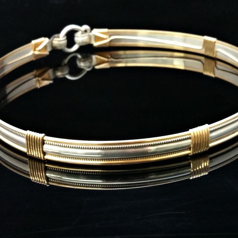 The JANUS collection of artisan BDSM jewelry is reminiscent of ancient Rome. The Janus Submissive Collar is a locking collar made of gleaming sterling silver with 14k gold filled accents