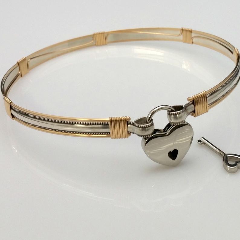 The JANUS collection of artisan BDSM jewelry is reminiscent of ancient Rome. The Janus Submissive Collar is a locking collar made of gleaming sterling silver with 14k gold filled accents