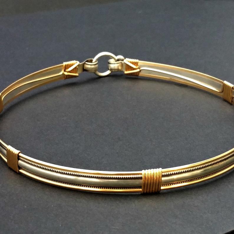 The JANUS collection of artisan BDSM jewelry is reminiscent of ancient Rome. The Janus Submissive Collar is a locking collar made of gleaming sterling silver with 14k gold filled accents