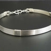 The Lodi locking submissive collar in sterling with Irish Good Luck medallion in amethyst. The collar can be worn alone or with collar enhancers.