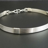 The Lodi locking submissive collar in sterling with Irish Good Luck medallion in amethyst. The collar can be worn alone or with collar enhancers.