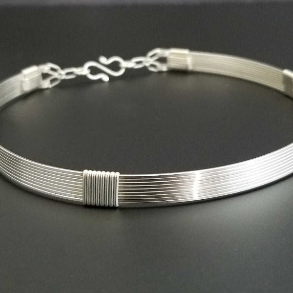 The Lodi locking submissive collar in sterling with Irish Good Luck medallion in amethyst. The collar can be worn alone or with collar enhancers.