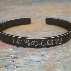Share a secret. Ancient looking fonts create a unique cuff with a secret message. The outside inscription is Kanji Symbols.