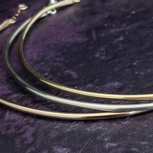 Three MINIMALIST LOCKING COLLAR {Precious Metals} hoop earrings by MY SECRET HEART STUDIOS on a purple surface.