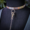 A sleek and simple chain collar of Stainless Steel gets it done. The handle is 10 inches of chain, so both small and large hands should fit easily. The 36 inch chain ends with a silver tone swivel trigger clip. Features a handcrafted sterling O Ring with a bail opening large enough to fit most all of our collars.