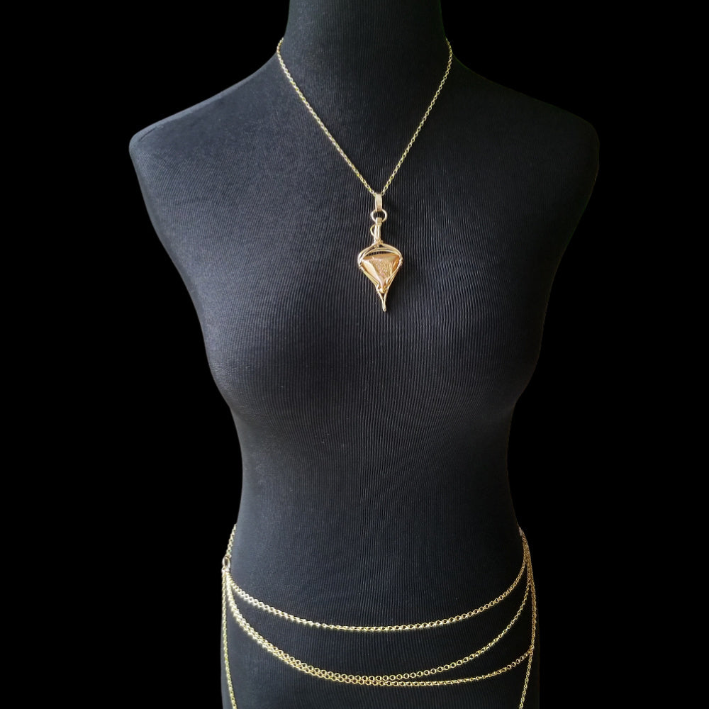 An incredibly luxurious look for a submissive collar. A triangular cut Gold Window Druzy is encased in a gold wire wrapped pendant that can be worn alone or slid onto most of our submissive collars. Featuring stunning open lattice work and a 14k gold filled chain that can be worn with a traditional clasp, or locked with a lock and key.