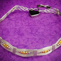 Bold and dramatic, and oh so sexy, this BDSM locking submissive collar will get plenty of attention. Yet it's so totally discreet, no one will ever know. Perfect statement of ownership for kittens, subs and slaves.   This wire wrapped collar is created in sterling silver, and has faceted sterling, 14k yellow and rose gold filled beads incorporated into the collar. With it's rounded, hand sculpted shape, this collar is very comfortable.   