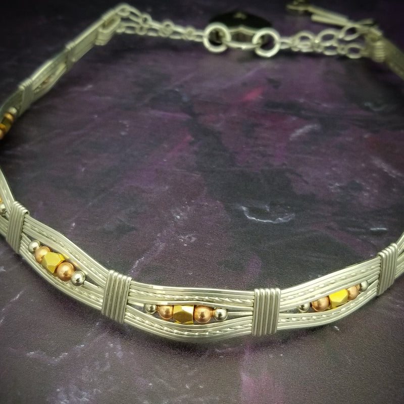 Bold and dramatic, and oh so sexy, this BDSM locking submissive collar will get plenty of attention. Yet it's so totally discreet, no one will ever know. Perfect statement of ownership for kittens, subs and slaves.   This wire wrapped collar is created in sterling silver, and has faceted sterling, 14k yellow and rose gold filled beads incorporated into the collar. With it's rounded, hand sculpted shape, this collar is very comfortable.   