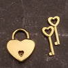 A pair of MY SECRET HEART STUDIOS gold heart-shaped lockets and keys.
