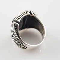 A signet style ring in sterling silver with an octagon-cut black onyx cabochon. Beautiful details include Celtic knots and beading on the top and bottom edges of the bezel.