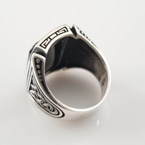 A signet style ring in sterling silver with an octagon-cut black onyx cabochon. Beautiful details include Celtic knots and beading on the top and bottom edges of the bezel.