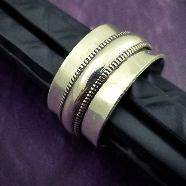From our JANUS COLLETION, this ring is the perfect companion to the submissive collars and handcuffs. Very substantial, this high-quality artisan ring will be enjoyed for a lifetime. A spinning band of the Janus pattern in sterling on a hefty band of sterling silver. All handcrafted.