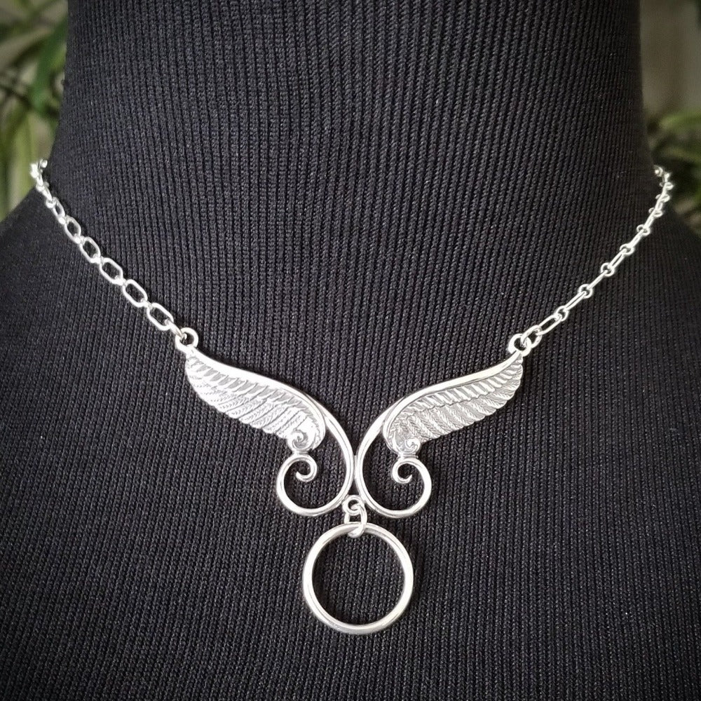 An locking, soft collar for your angel. This angel wing collar pays homage to your BDSM D/s lifestyle and has an O ring attached. Can be worn locked, or with a traditional clasp for discretion. Created with sterling silver chain, suitable for everyone, everyday. Do you think anyone will know what the classic 'Story of O' ring is for??