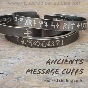 Share a secret. Ancient looking fonts create unique cuffs with a secret message. The outside inscription is Kanji symbols. Traditional Cuff with gap. All Sterling Silver, heavily oxidized. Message: You Are My Secret Heart