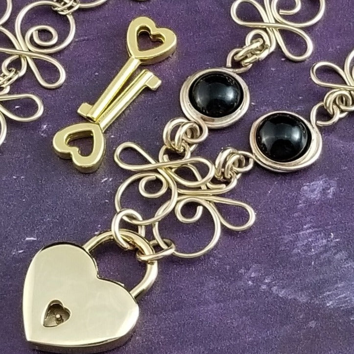 Made a bold statement of your Dominant / submissive lifestyle. The CELTIC PRIESTESS locking submissive collar features chain links inspired by Celtic knots, all created entirely by hand. Embellished with 2 natural Black Onyx gemstone cabochons. My Secret Studios 001